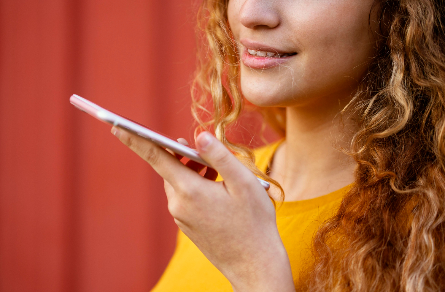 Persona realizando un pago digital con comando de voz en un smartphone, representando la autenticación biométrica vocal.